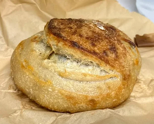 A rustic sourdough loaf with a crackly scored crust